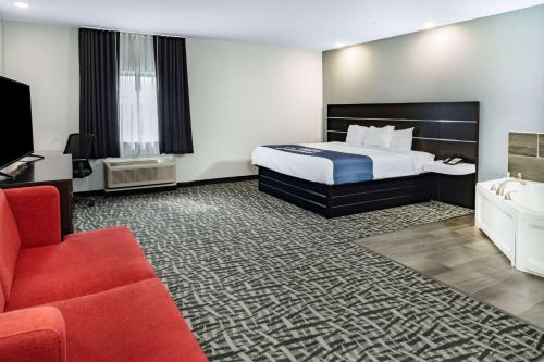 a hotel room with a bed and a couch at Days Inn & Suites by Wyndham Horn Lake - Memphis Graceland in Horn Lake