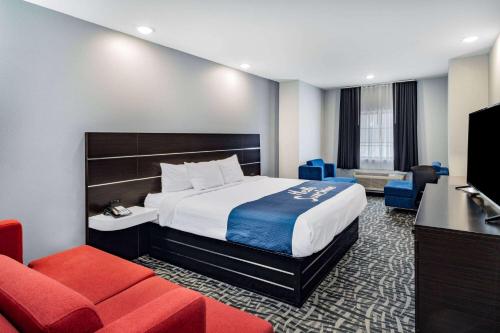 une chambre d'hôtel avec un lit et un canapé dans l'établissement Days Inn & Suites by Wyndham Horn Lake - Memphis Graceland, à Horn Lake