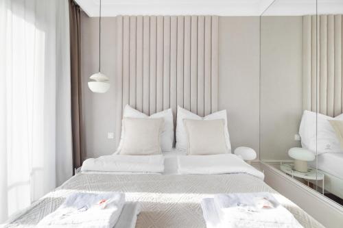 グダニスクにあるGREAT Residenceの白いベッドルーム(白い枕付きのベッド2台付)