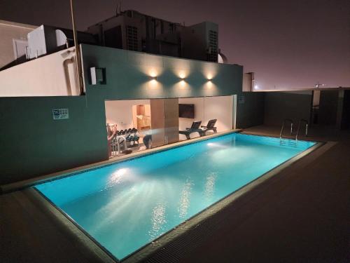 una gran piscina en la parte superior de un edificio por la noche en Terminal Inn Al Mansoura en Doha