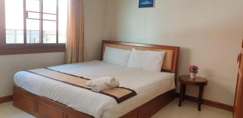 um quarto com uma cama com um bicho de peluche em NAVY HOME HOTEL โรงแรมเนวี่โฮม em Mae Sai