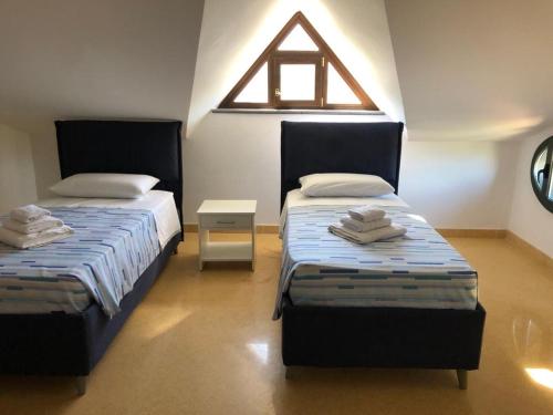 dwa łóżka w pokoju z oknem w obiekcie B&B ELIA w mieście Giffoni Sei Casali