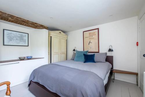 a bedroom with a large bed with blue pillows at The Brew House in Bath