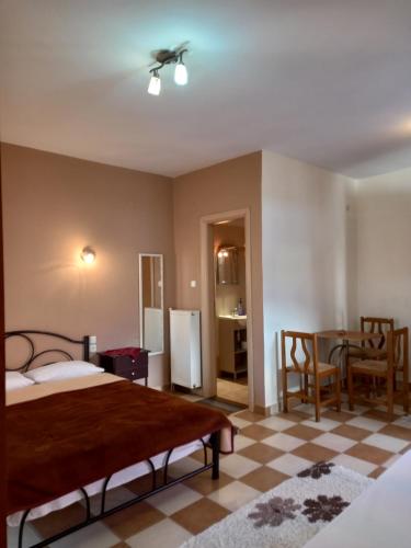 ein Schlafzimmer mit einem Bett und einem Tisch sowie eine Küche in der Unterkunft Nikos's apartment in Taxiarchis