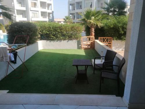 a patio with a lawn with chairs and a table at Aqua marine - comfort vacation home with pool view in Sharm El Sheikh