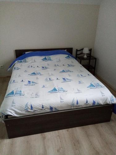 un letto con piumone blu e bianco di Chez Maniche a Cayeux-sur-Mer