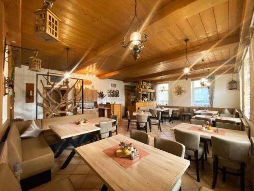 un restaurante con techos de madera, mesas y sillas en Landgasthof Kanz en Tanna
