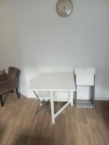 - un bureau blanc dans une chambre avec une horloge murale dans l'établissement Le Fayolle - Lumineux 2 pièces en centre-ville, à Dieppe