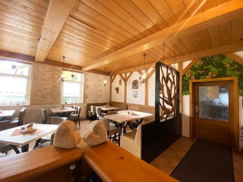 a restaurant with tables and chairs and wooden ceilings at Landgasthof Kanz in Tanna