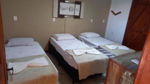 a room with two twin beds with towels on them at Pousada Cordel de Itaúnas in Itaúnas