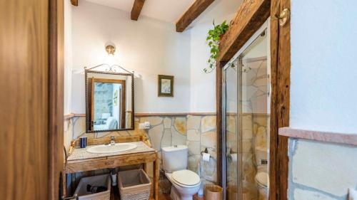 a bathroom with a toilet and a sink and a mirror at Casa El Imperio Gaucín by Ruralidays in Gaucín