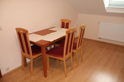 a dining room table and four chairs in a room at Jurincom apartments in Karlovy Vary