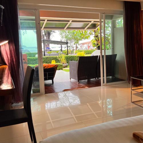 a living room with glass doors and a dining room at Mama Beach Residence - Adults Only in Phi Phi Don