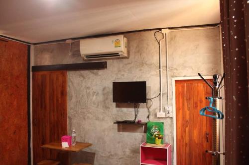 a room with a wall with a television and a door at เฮือนอุ้ยดี2 in Ban Khua Nam Chun