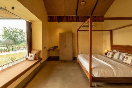 sypialnia z łóżkiem z baldachimem i dużym oknem w obiekcie 1br Cottage with Pool - Eagle's Nest by Roamhome w mieście Udaipur