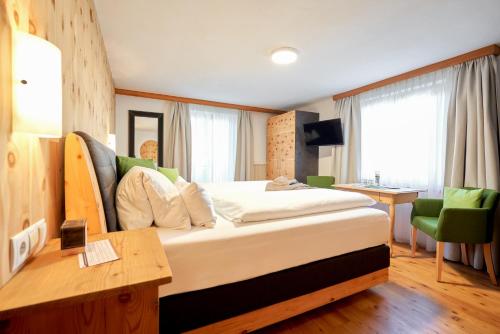 a hotel room with a large bed and a desk at Bio-Pension Bliem in Altenmarkt im Pongau