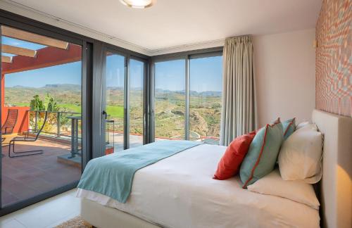 a bedroom with a bed and a large glass window at Las Terrazas Villa 3 in Salobre