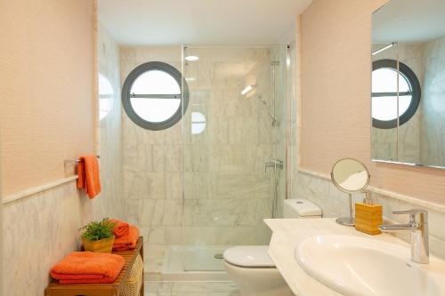 een badkamer met een toilet, een wastafel en een douche bij Las Terrazas Villa 3 in Salobre