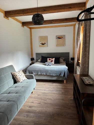 ein Schlafzimmer mit einem Bett und einem Sofa in der Unterkunft Chata Borówkowe Wzgórze in AdamÃ³w