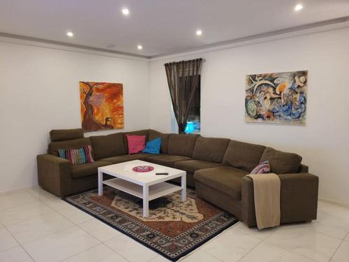 a living room with a couch and a table at Beautiful terraced house with private parking in Sandviken