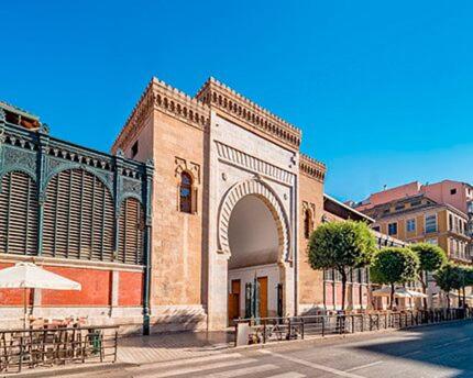 a large brick building with an arch in a street at Estudio Arriola Suite in Málaga