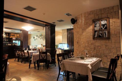 a restaurant with tables and chairs and a brick wall at Park Hotel Sandanski in Sandanski