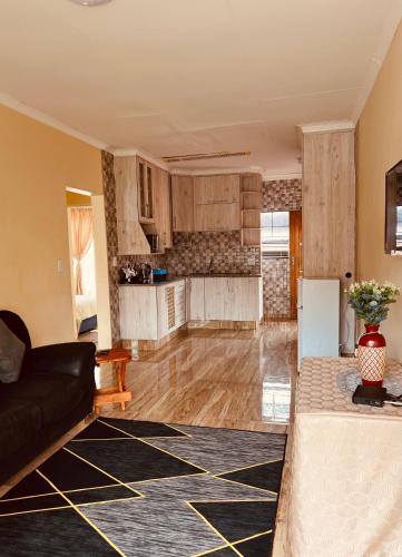 a living room with a couch and a kitchen at Mont Pelaan 88 in Newcastle