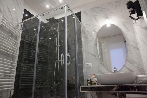 La salle de bains est pourvue d'une douche, d'un lavabo et d'un miroir. dans l'établissement B&B Morelli Home, à Cosenza