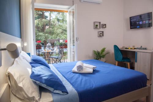 a bedroom with a blue bed with towels on it at B&B Morelli Home in Cosenza