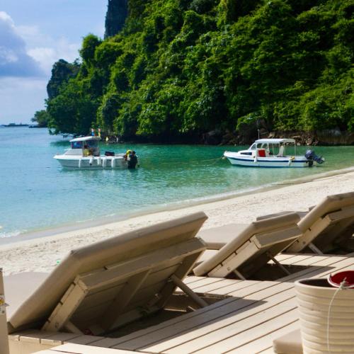 two boats are in the water on a beach at Mama Beach Residence - Adults Only in Phi Phi Don