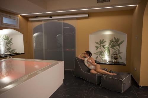 a woman sitting in a chair in a room at Grand Hotel San Gemini I UNA Esperienze in San Gemini