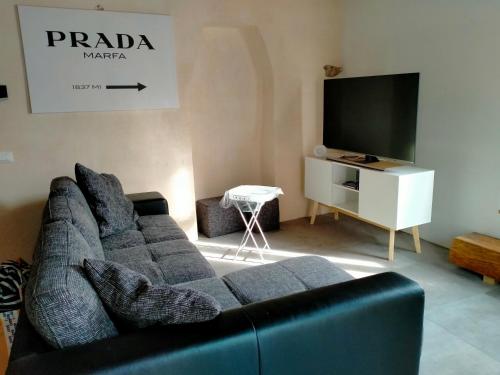 uma sala de estar com um sofá e uma televisão de ecrã plano em Maison Cascina Amélie em Abbadia Lariana