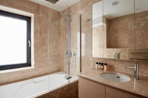 y baño con lavabo y ducha acristalada. en Maddox Street - 3 bed en Londres