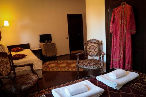 ein Wohnzimmer mit einem Bett und Stühlen sowie einem TV in der Unterkunft Hadrianus Hotel in Antalya