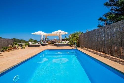 a blue swimming pool in a yard with a fence at Ideal Property Mallorca - Els Moyans in Muro