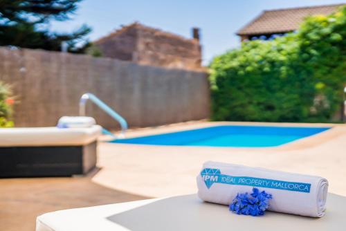 un dispositivo sentado en una mesa frente a una piscina en Ideal Property Mallorca - Els Moyans, en Muro