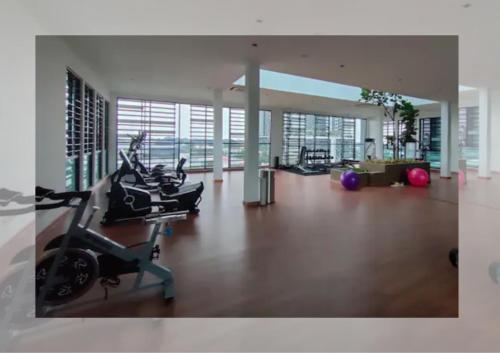 a gym with treadmills and exercise bikes in a building at Cozy 2R2B Relaxing Skyline Views #GA2 in Shah Alam