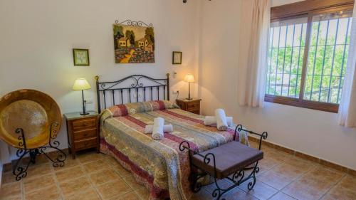 1 dormitorio con 1 cama, 1 silla y 1 ventana en El Romo Colmenar by Ruralidays, en Colmenar