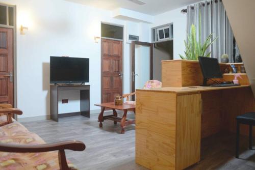 een woonkamer met een bureau en een televisie bij North Edge Inn in Kanditheemu