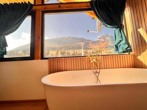 a bath tub in a room with a window at View Piatra Craiului in Zărneşti