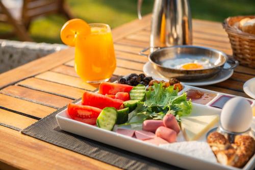 un piatto di frutta e verdura su un tavolo con una bevanda di Hotel Simsek a Edirne