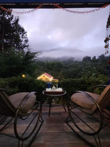 a patio with two chairs and a table with a view at Chalet los Pinos Constanza in Arroyo Frío
