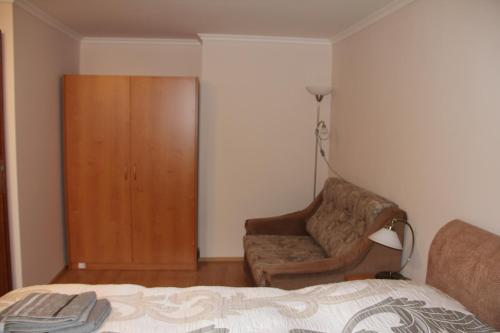 a bedroom with a bed and a chair and a closet at Jurincom apartments in Karlovy Vary