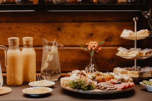 a table topped with plates of food and bottles of milk at Noclegi JuraPark Krasiejów in Krasiejów