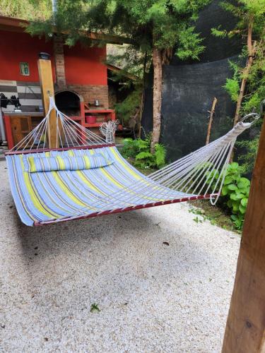 a hammock in a garden in front of a house at Chalet los Pinos Constanza in Arroyo Frío