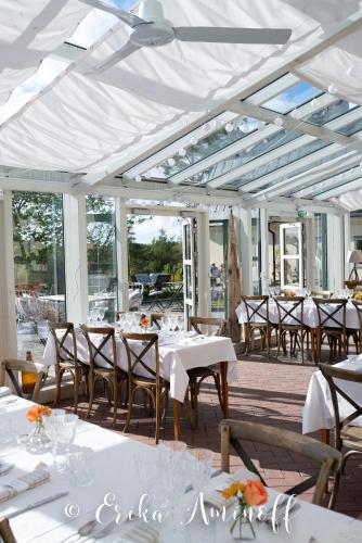 a dining room with white tables and chairs at Fredriksborg Hotell & Restaurang in Värmdö