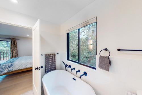 a white bathroom with a tub and a bed at Pebble Beach Abundant Oasis in Pebble Beach