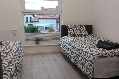 a bedroom with a bed and a window at Urokliwy Apartament Bałtyk 2 nieopodal Gdyni NEW in Pogórze