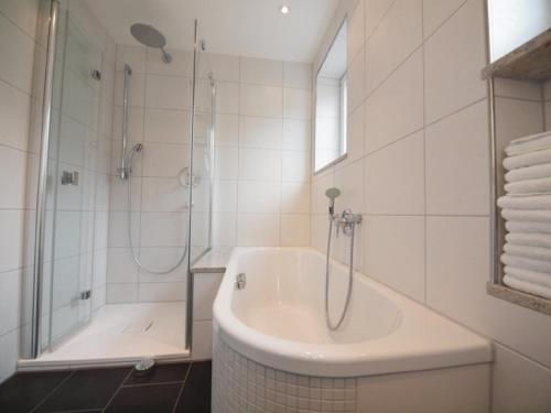 a white bathroom with a tub and a shower at Kaufhold Ferienwohnung in Immenstadt im Allgäu