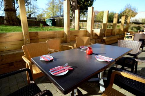 a black table with plates and napkins on a patio at Pelican London Hotel and Residence in London